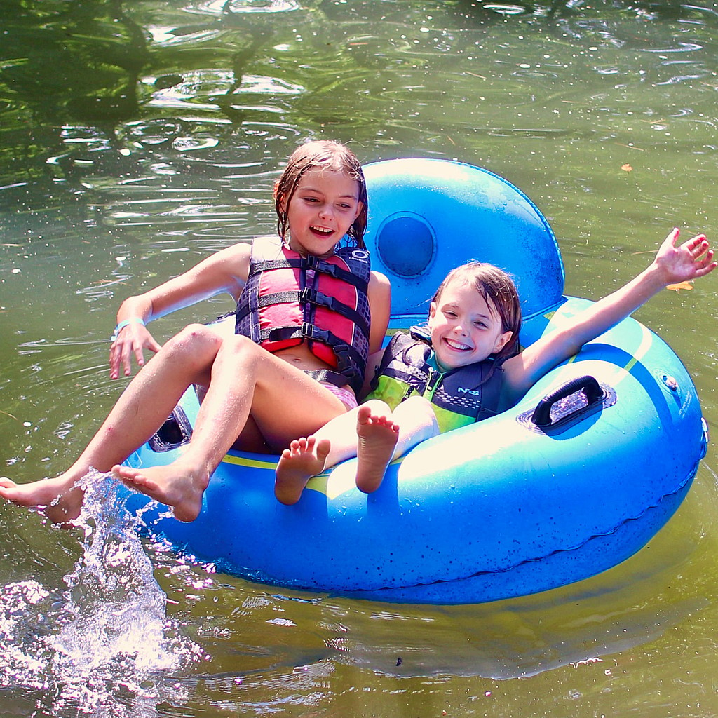 two camp kids floating in the lake