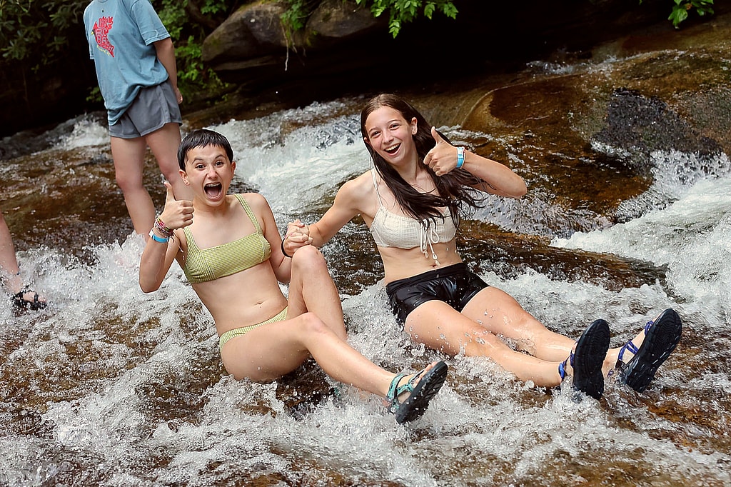 two campers show thumbs up on sliding rock