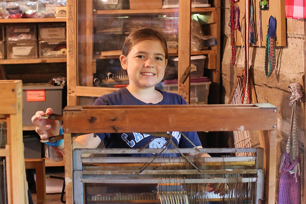 girl camp weaving at loom