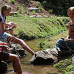 Girls weaving baskets by the creek