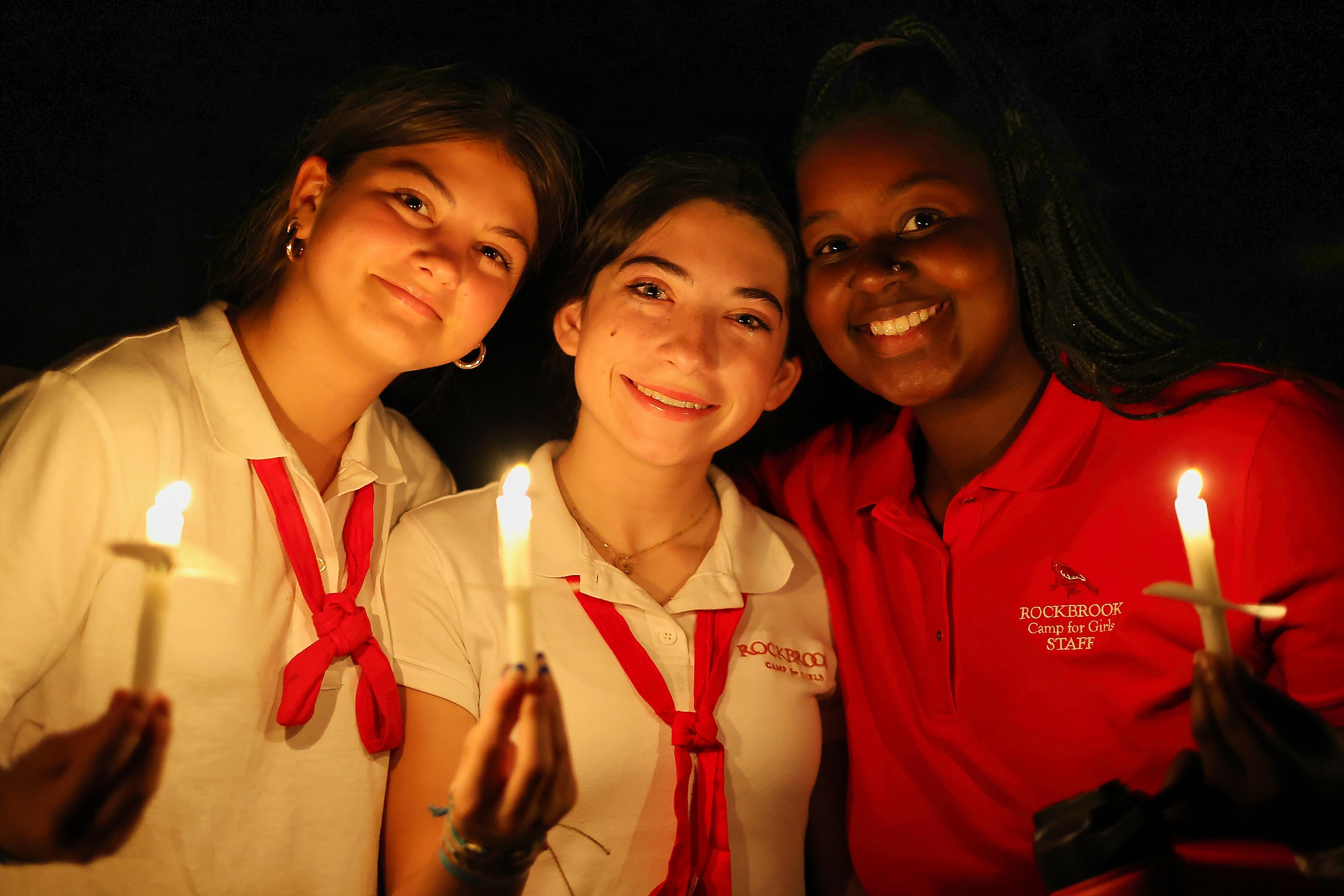 campers and counselor at campfire candle ceremony