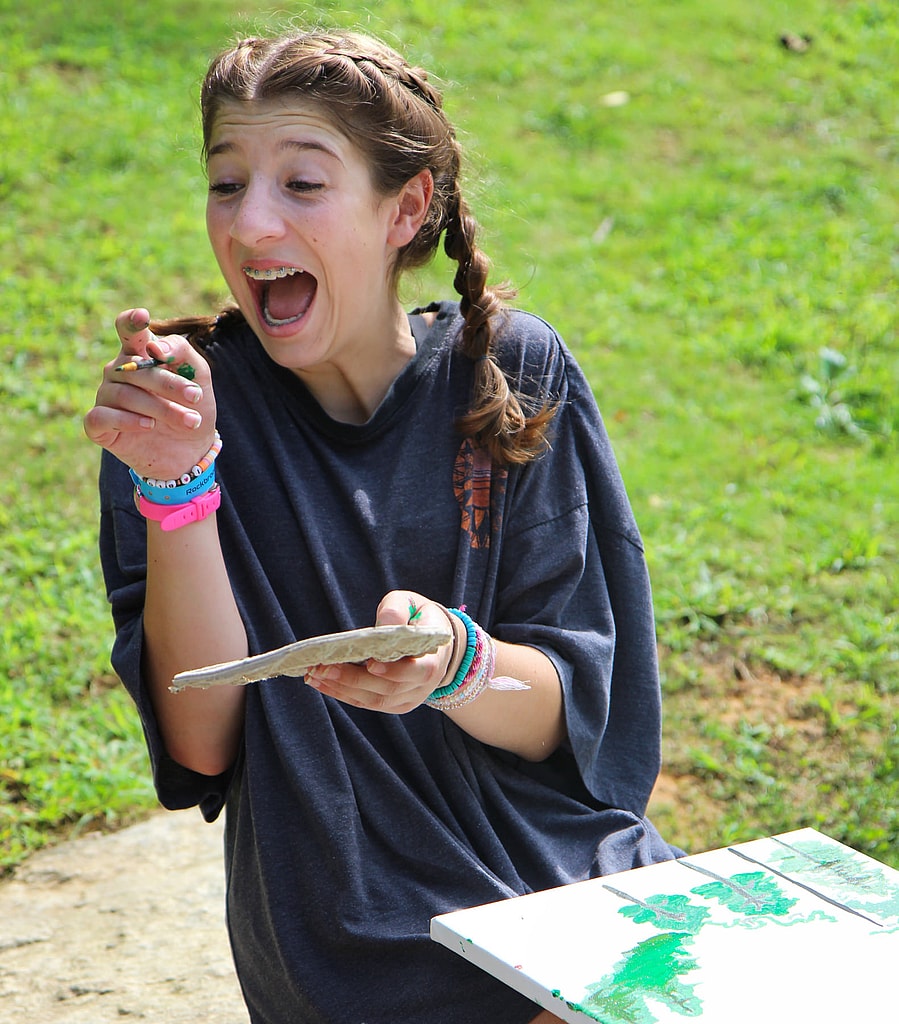 excited camp kid painting