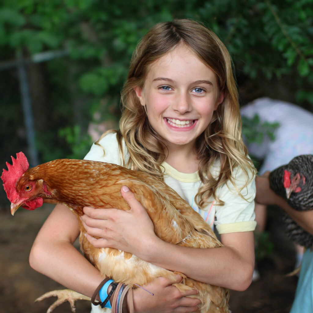 camper girl hugs a chicken
