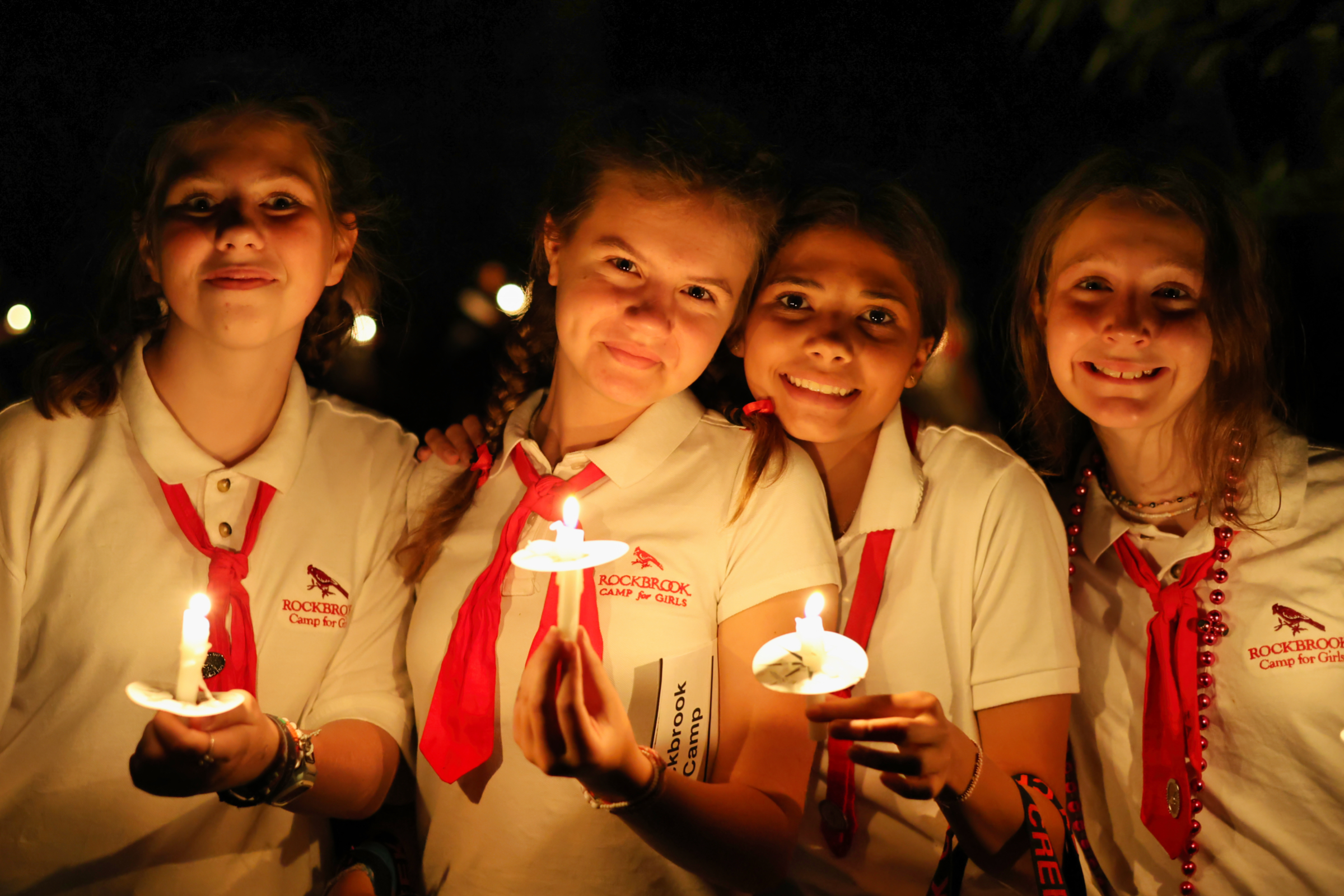 candlit summer camp girls at closing campfire