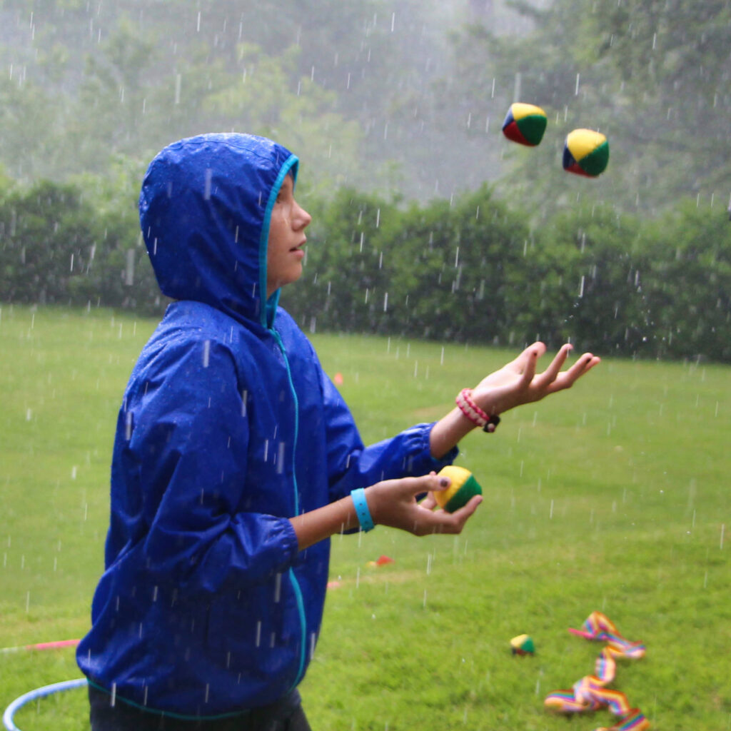summer camp kid juggling in the rain
