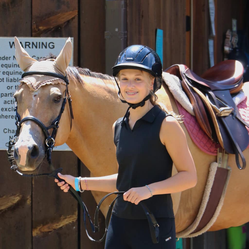 teen camp girl leading horse