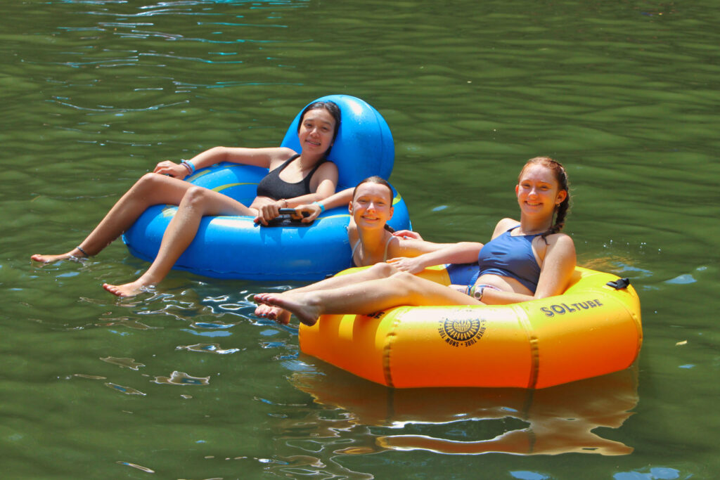 camp teens floating at lake